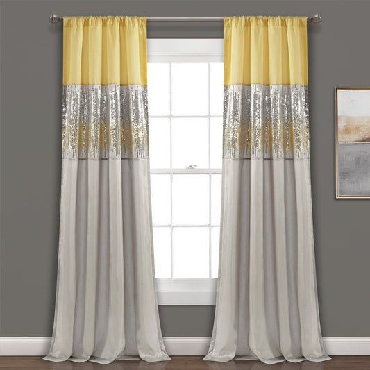 Yellow and gray striped curtains hanging in front of a window with a gray wall background. Shimmery and sparkly sequins curtain panel.
