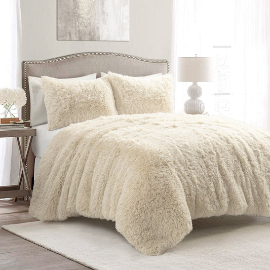 Beige fuzzy comforter on a bed in a bedroom setting. Faux fur bedding bed set.