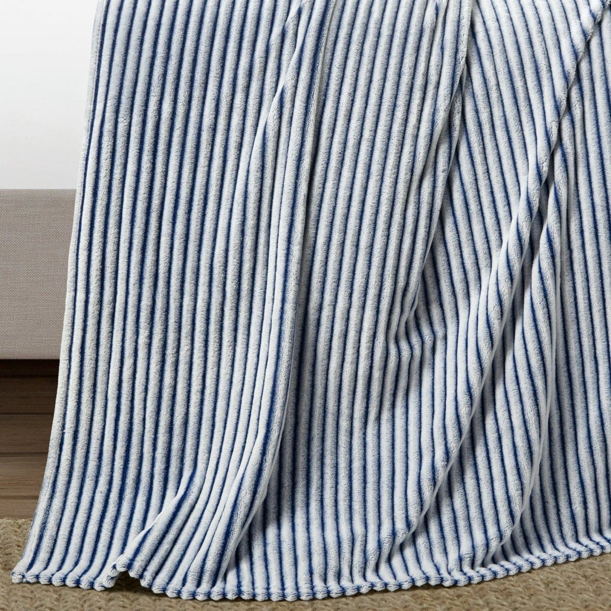 Blue and white striped blanket draped over a Wrap Yourself in Luxurious Comfort
Discover the ultimate in cozy relaxation with the Ribbed Faux Fur Oversized Blanket by LushDecor