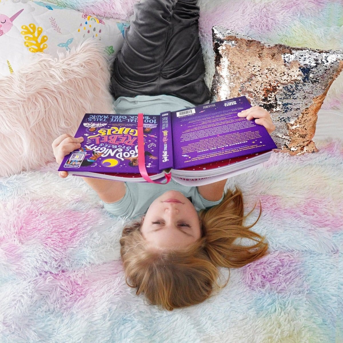Bed with a colorful comforter in a bedroom setting. Pastel tiedye in a bedroom setting. Faux fur bedding. Girls.