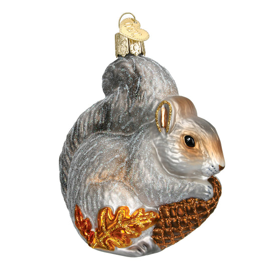 Glass ornament of a squirrel with autumn leaves on a white background