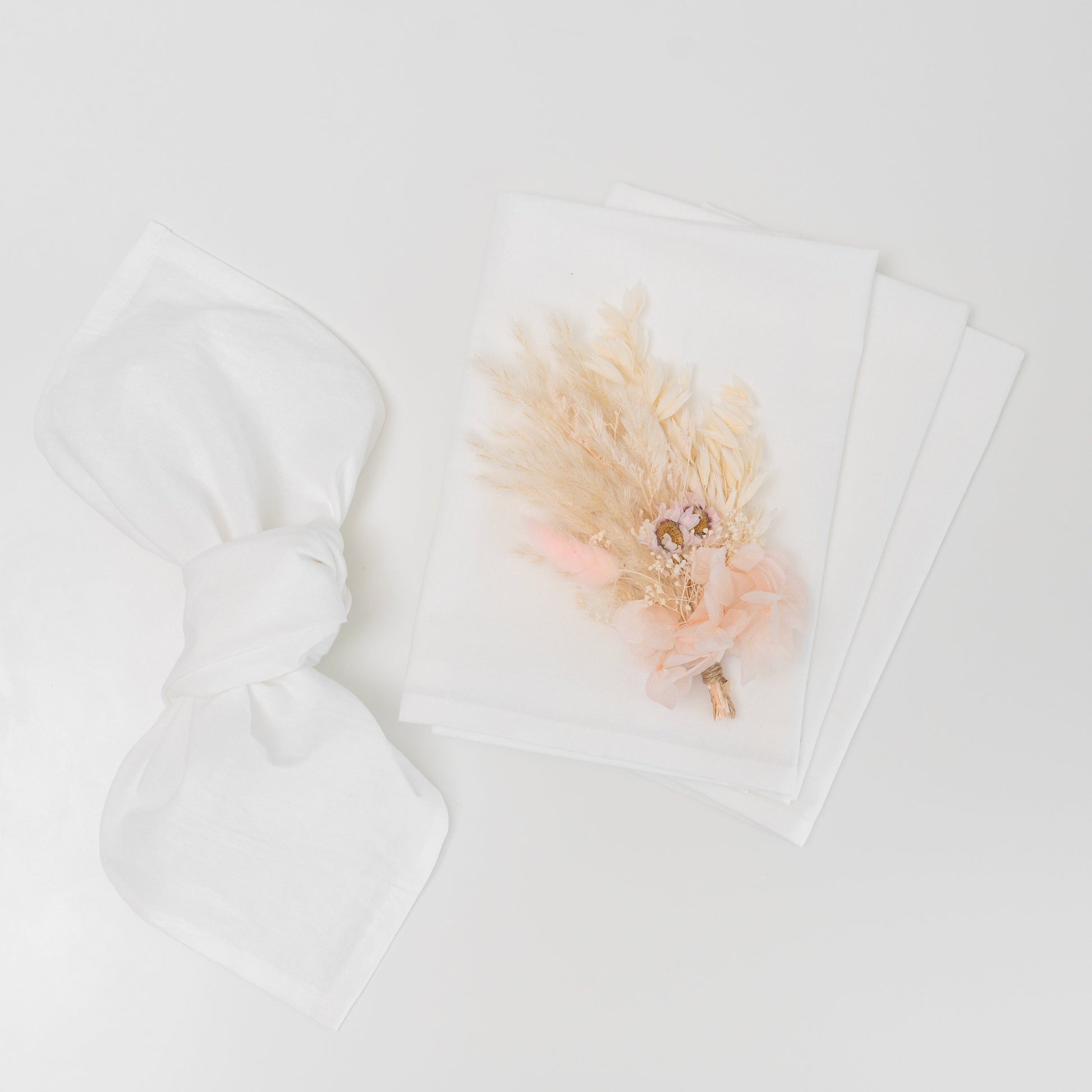 Floral arrangement on a white surface with a white card