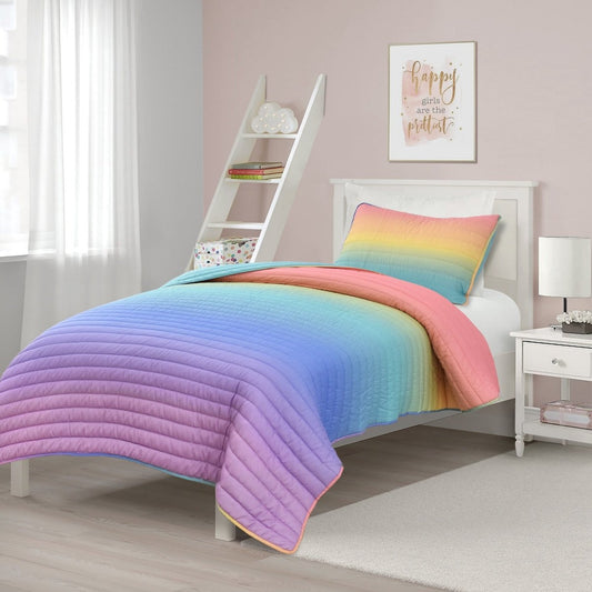 Bed with colorful quilt and matching pillow. Ombre rainbow bedding set. 