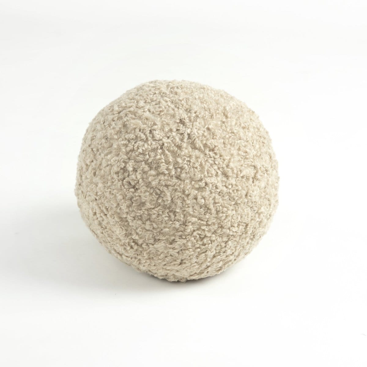 Textured balls in white, blue, gray, and beige on a light gray background. Round throw pillows show curly boucle texture. 