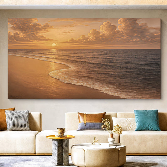 A large rectangular wall art print showing a golden beach sunset with waves, displayed above a beige sofa in a modern living room setting.