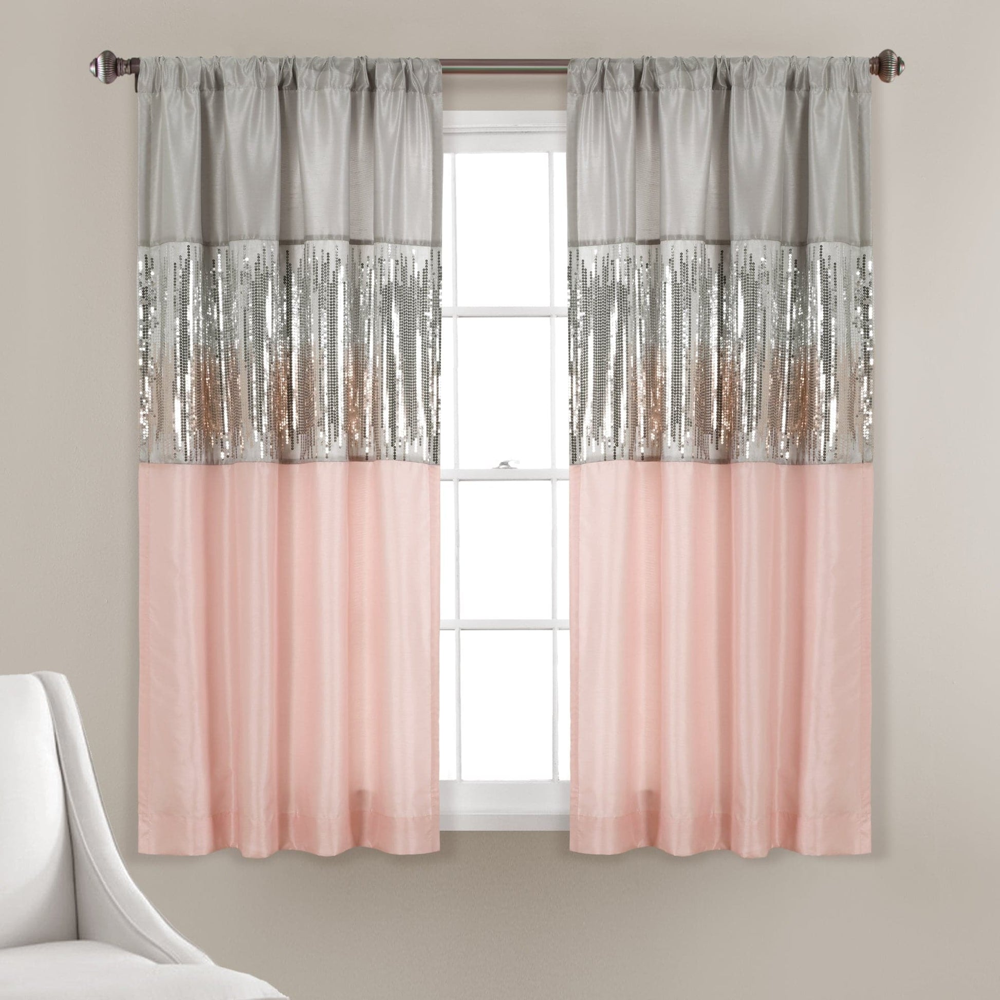 Window with pink and silver sequin curtains on a neutral wall.