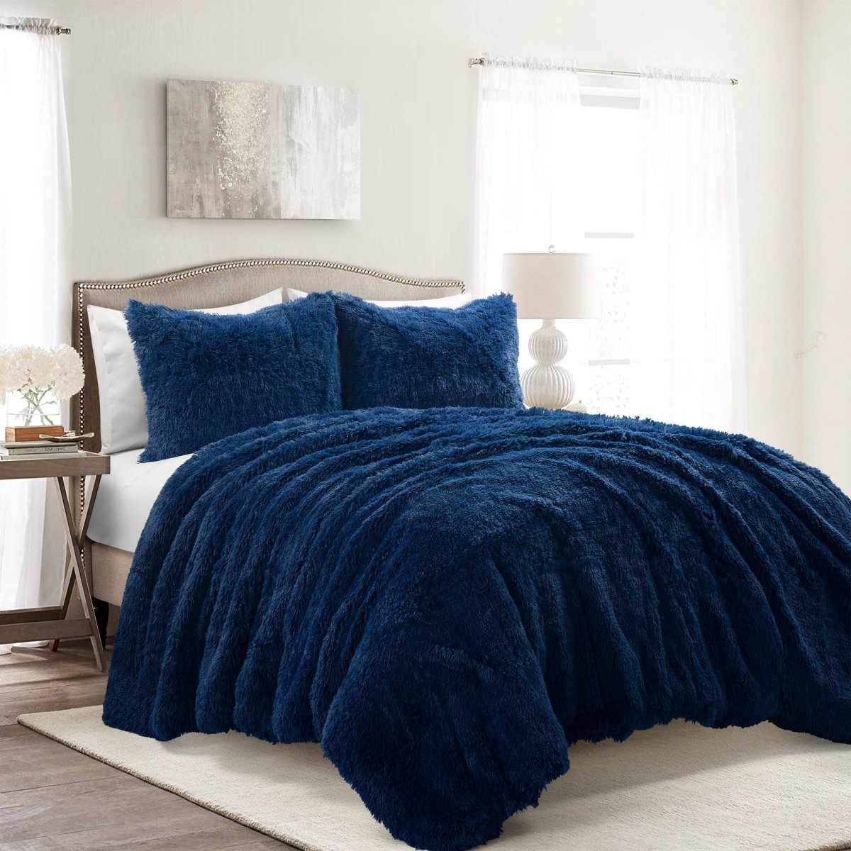 Blue textured comforter set on a bed in a bedroom with white walls and decor.Faux fur bedding bed set.