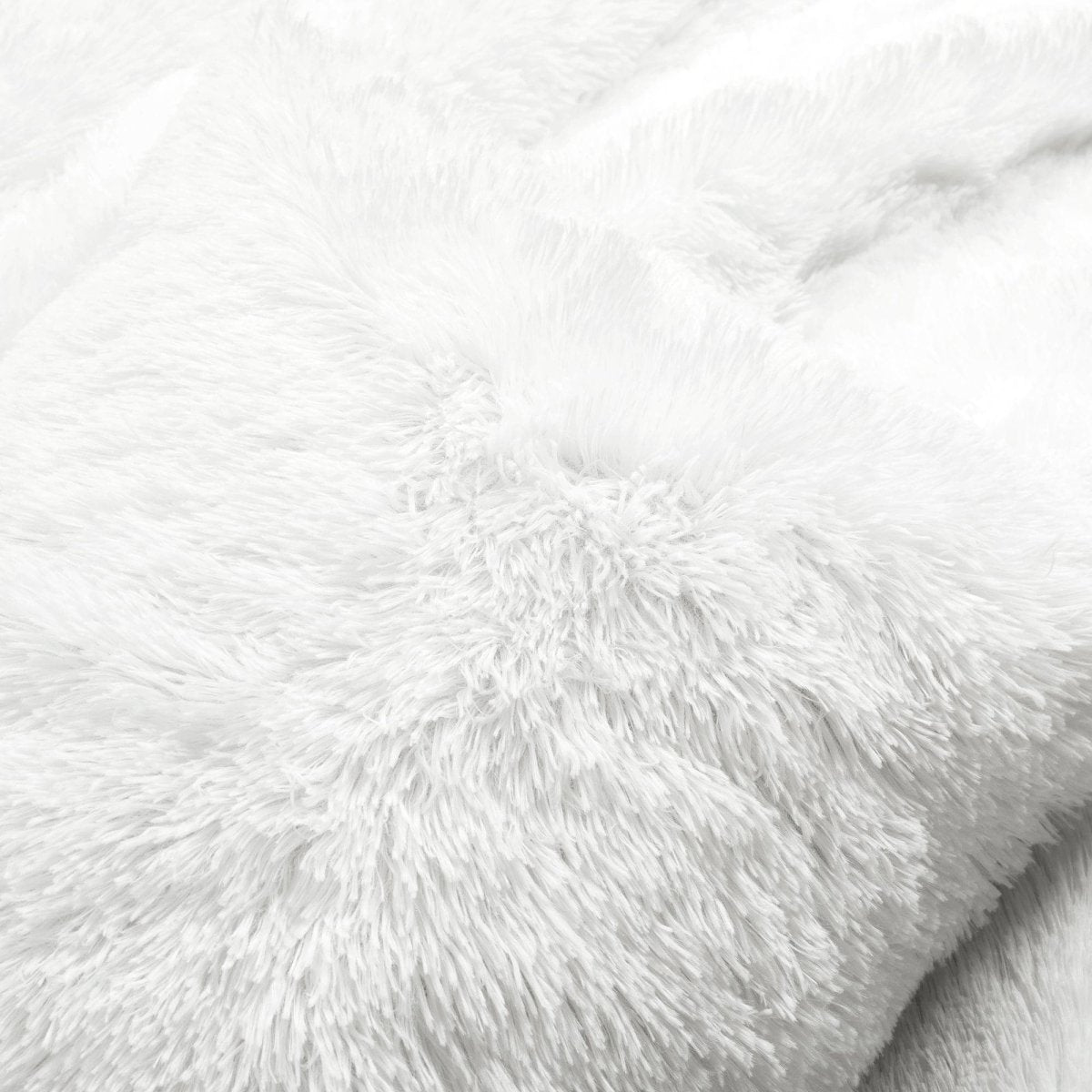 Close-up of white fluffy fabric texture. Faux fur bedding.