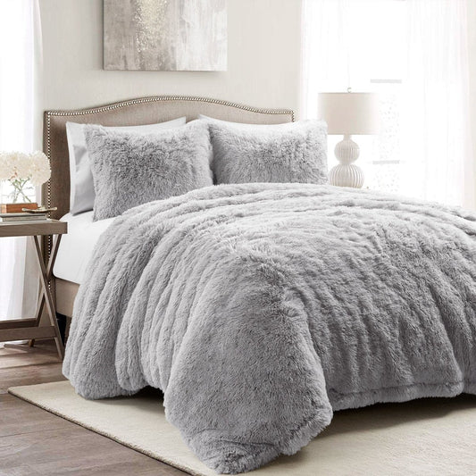 Gray fuzzy comforter set on a bed in a bedroom setting.White textured comforter on a bed in a bright bedroom setting. Faux fur bedding