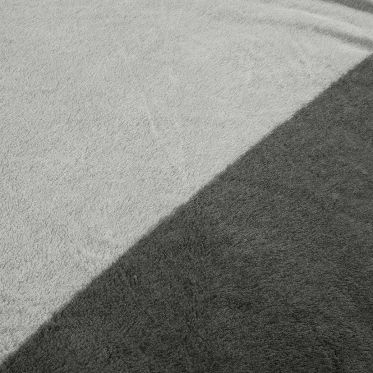 Close-up of a textured gray surface with a shadow showing plush detail