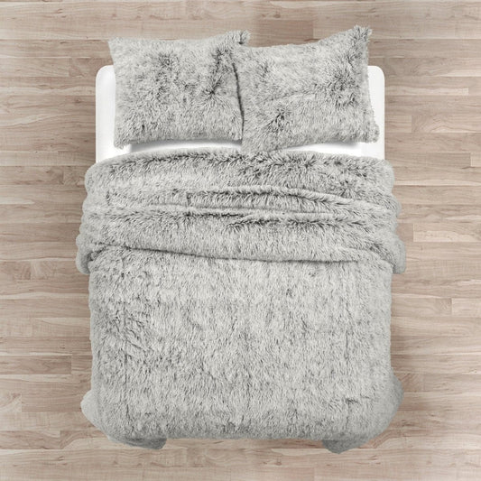 Gray textured comforter set on a bed with wooden flooring.