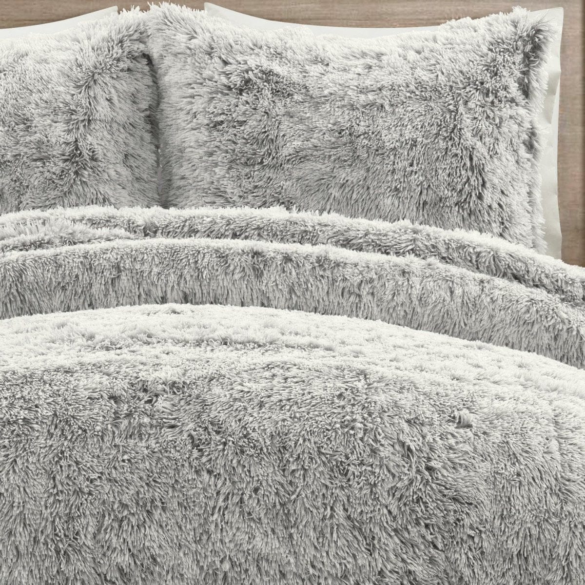 Gray fluffy comforter and pillows on a bed - Ultra-soft two-tone faux fur comforter set by LushDecor. Complete bedding set with comforter & shams. Machine washable luxury. 8.5 lbs, all-season comfort.