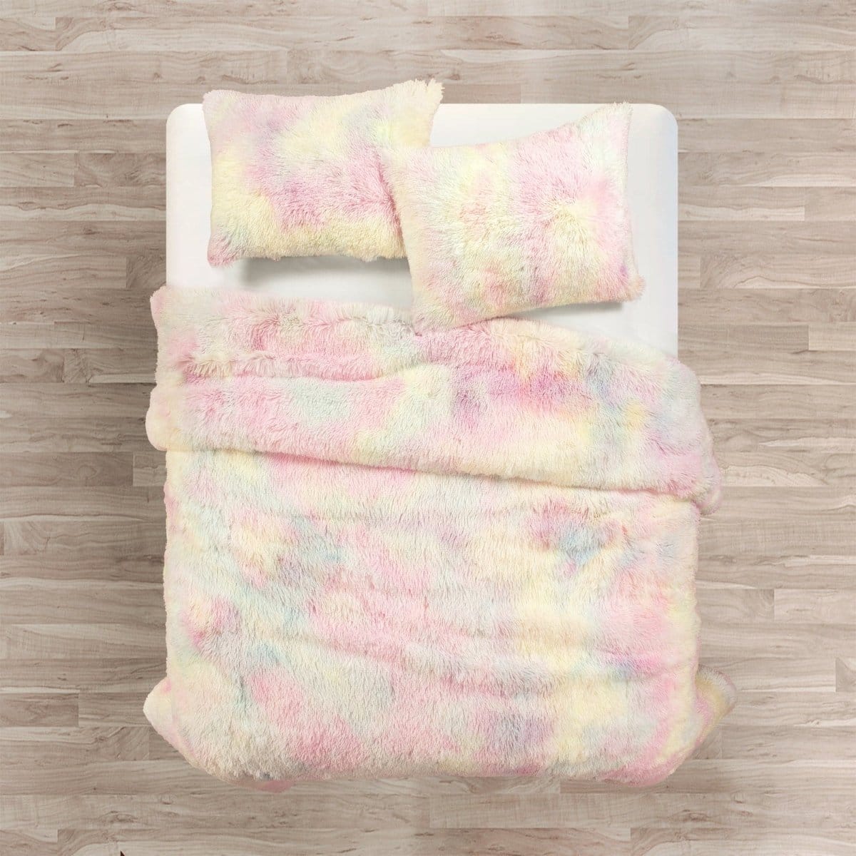 Pastel tie-dye comforter set on a bed with wooden floor background. Pastel tie-dye comforter set in a bedroom setting. Faux fur bed in bag