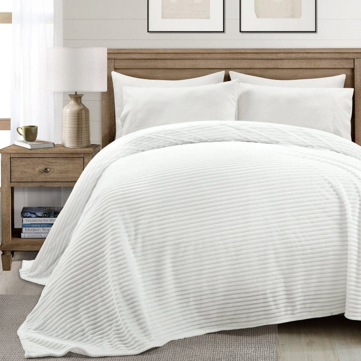White quilted coverlet on a bed with pillows and a nightstand in a bedroom setting.faux fur blanket, oversized blanket, cozy bedding, luxury throw, bedroom decor