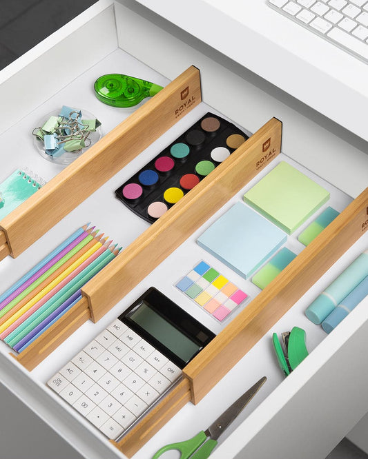 Open drawer with organized stationery items using a bamboo organizer. Dividers