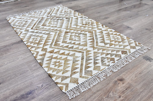 Geometric patterned rug with white and beige colors on a wooden floor.