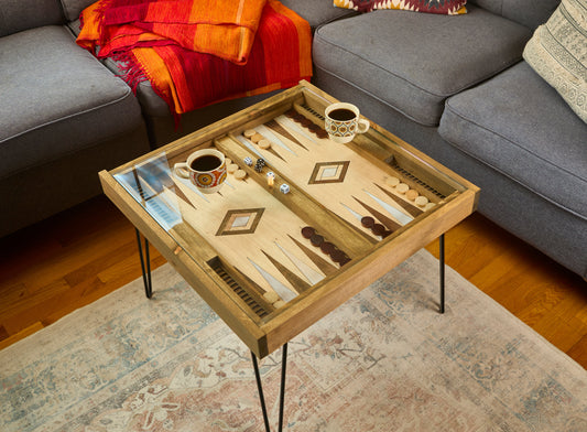 Wooden backgammon board with pieces on a coffee table in a living room.