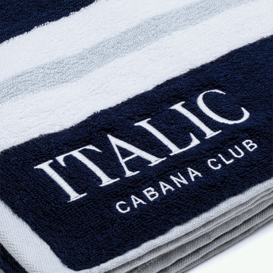 Stack of towels with 'Italic Cabana Club' branding on a white background