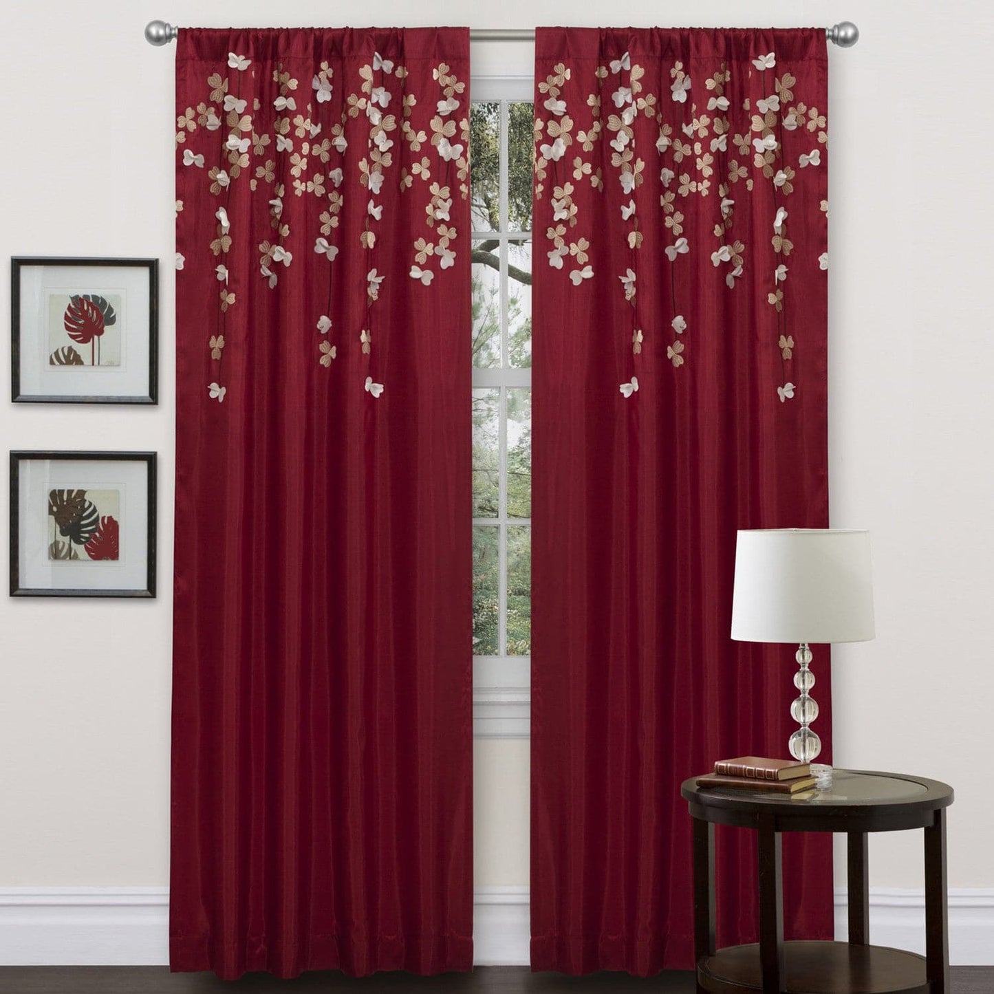 Red floral curtains with a side table and lamp in the foreground. floral drop embroidered curtain 