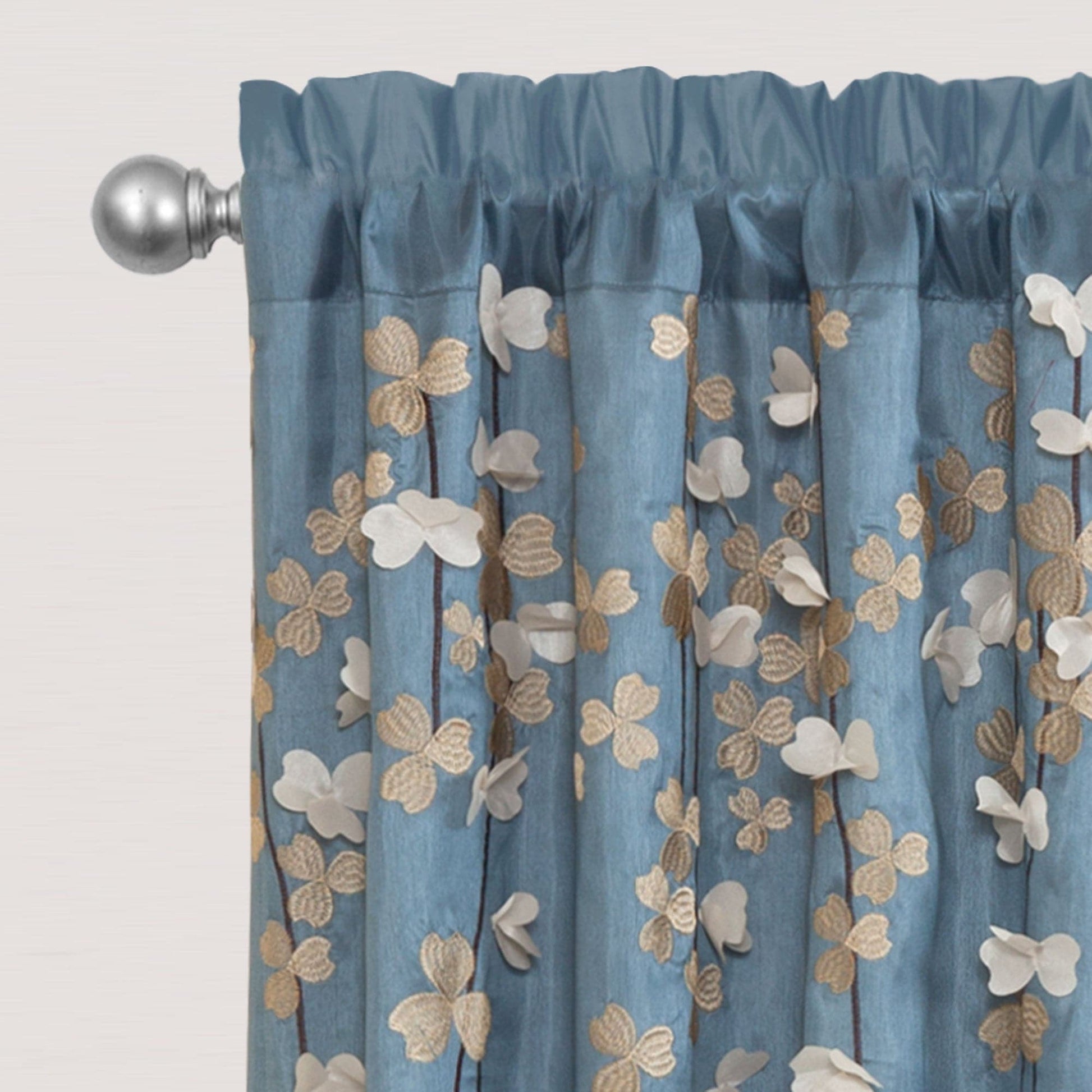 Blue floral drop embroidered curtain with a decorative rod on a light gray background
