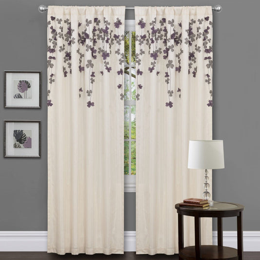Beige floral curtains with a side table and lamp against a gray wall. floral drop embroidered curtain 