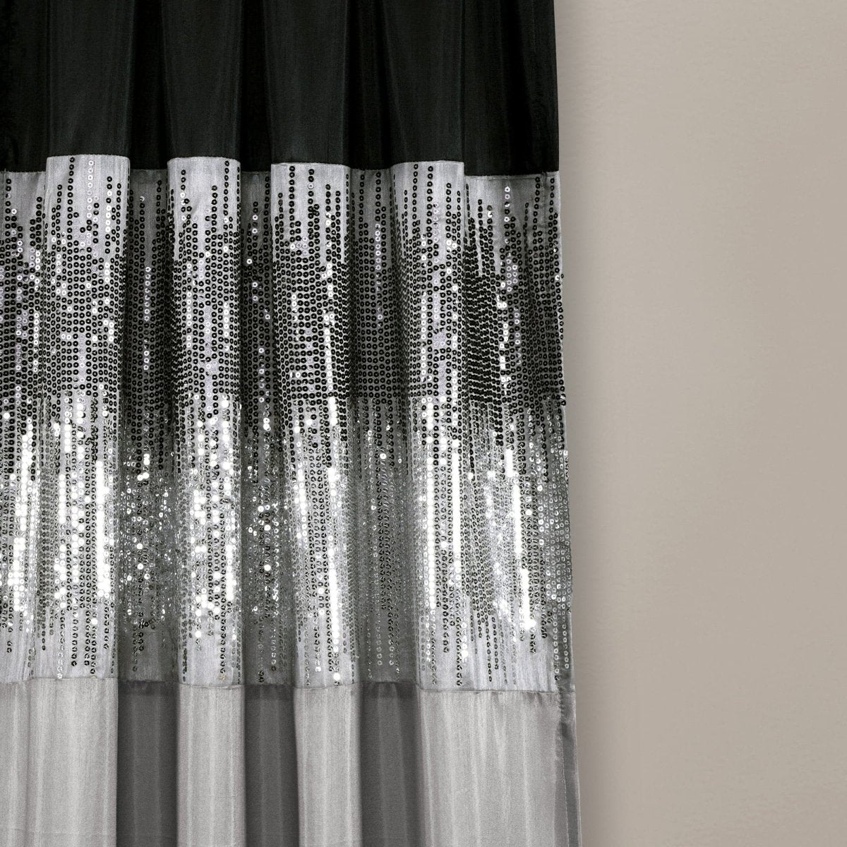 Black and silver sequin curtain against a beige wall