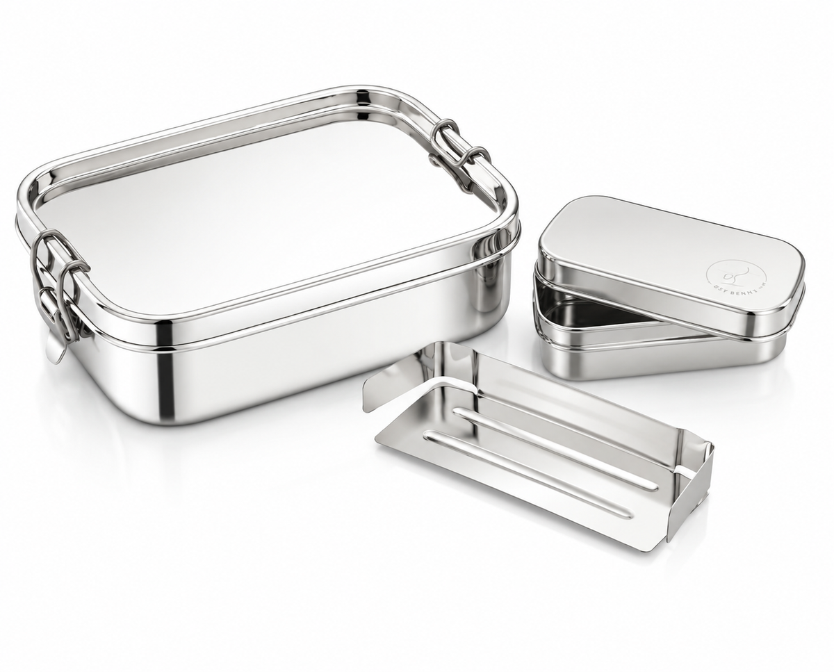 Set of silver metal lunch boxes and cutlery on a white background