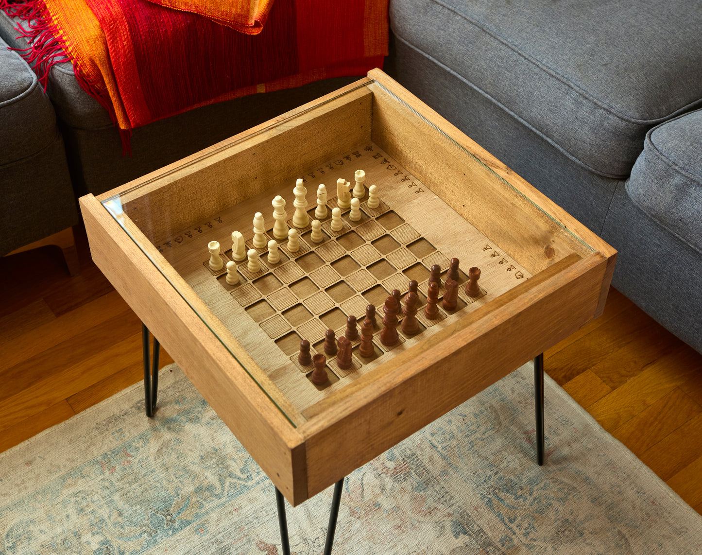 Wooden game table with chess pieces on a living room floor