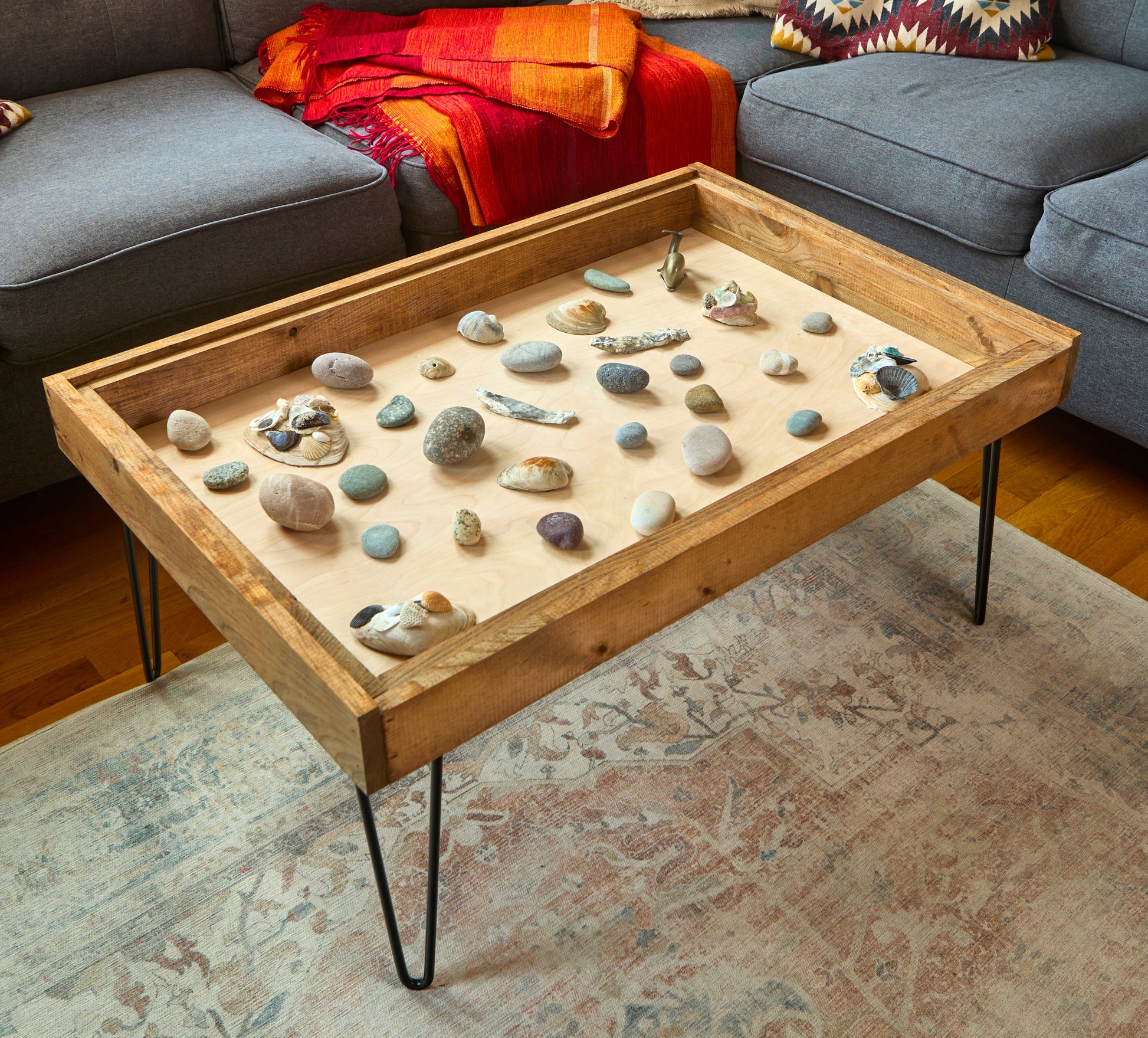 Wooden coffee table with pebbles in a living room setting