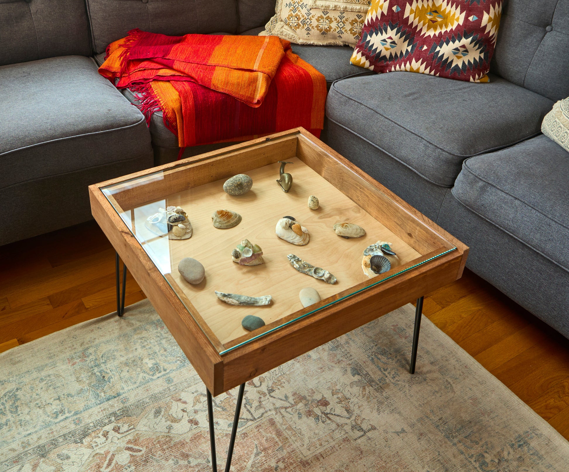 Wooden coffee table with decorative stones in a living room setting