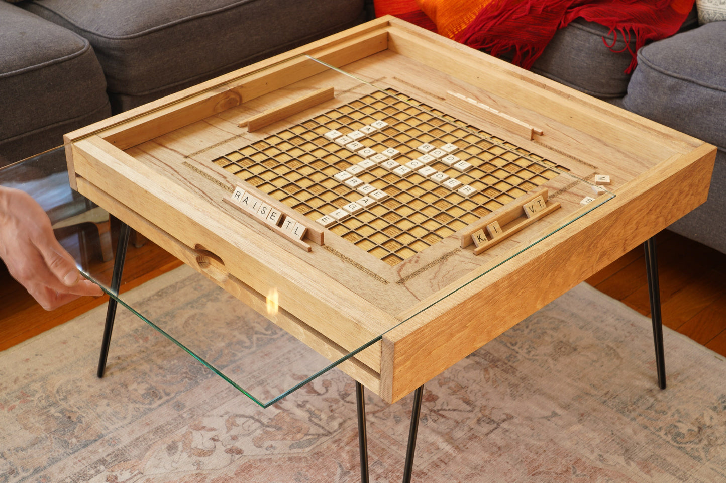 Wooden game board with glass top on a living room floor