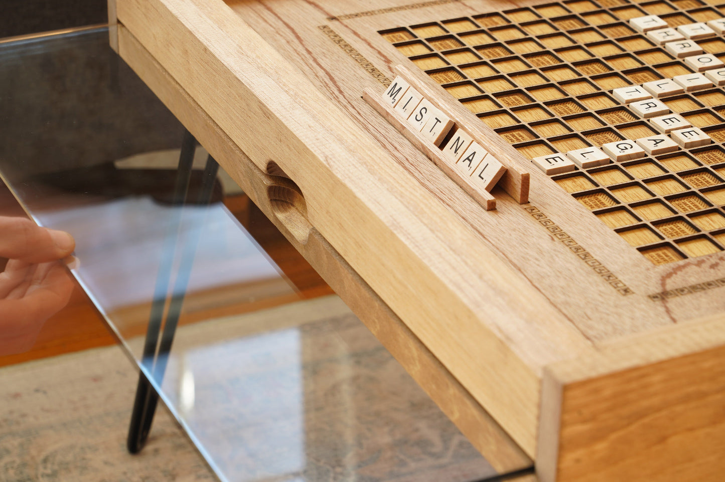 Wooden scrabble board with tiles on a glass surface