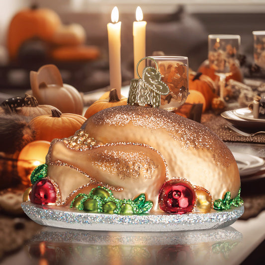 Turkey Platter ornament from Old World Christmas. A golden-brown roast turkey rests on a silver-toned platter, surrounded by colorful garnish details and finished with glitter accents. 
