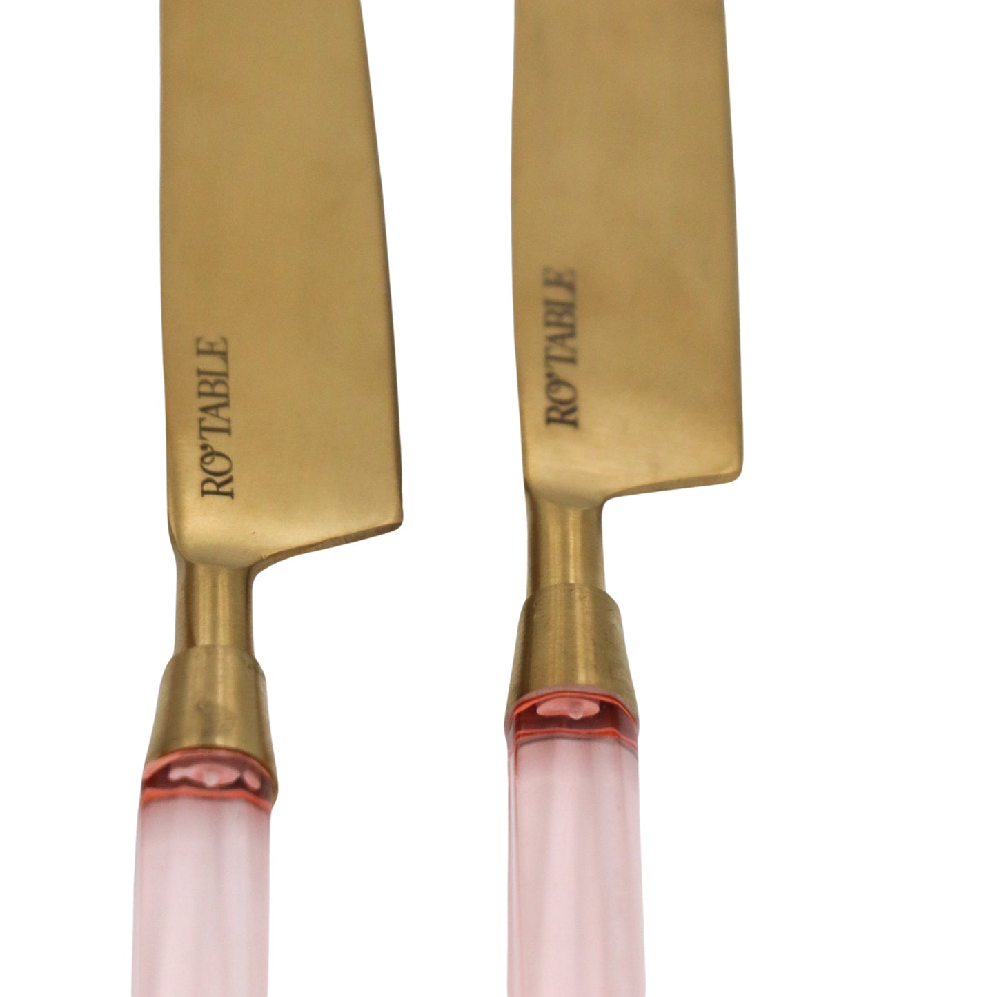 Two knives with gold blades and pink handles on a white background