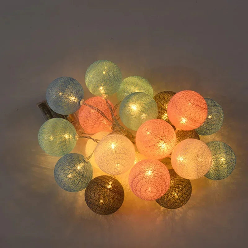 String of colorful cotton ball lights on a dark background