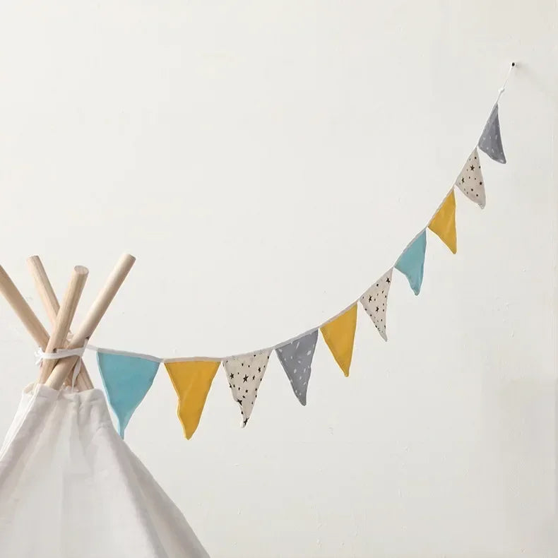 Colorful triangle flags hanging from a teepee against a white background