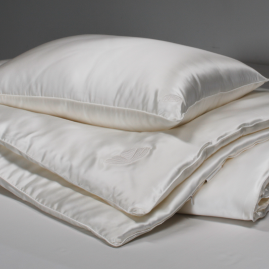 White silk pillow and duvet set on a gray background