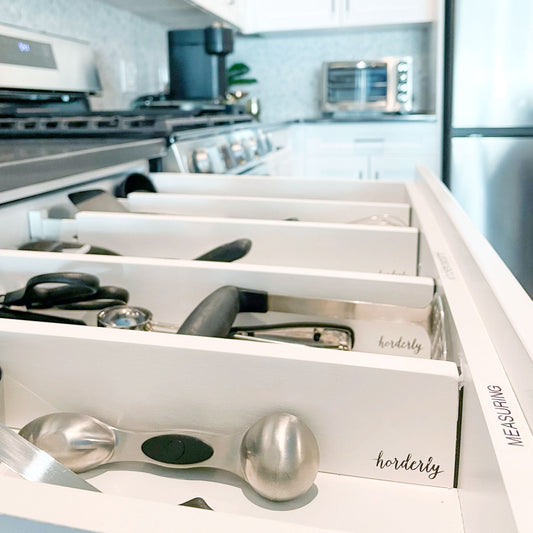 White rectangular expandable bamboo drawer separator with horderly branding example use in a kitchen drawer