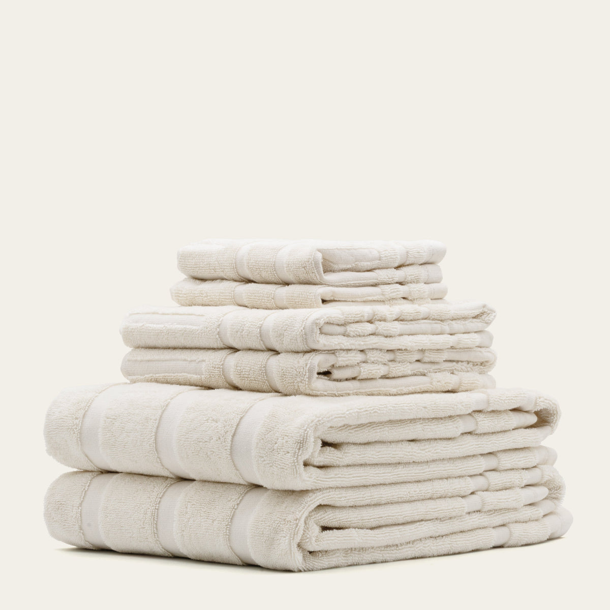 Stack of beige towels on a white background