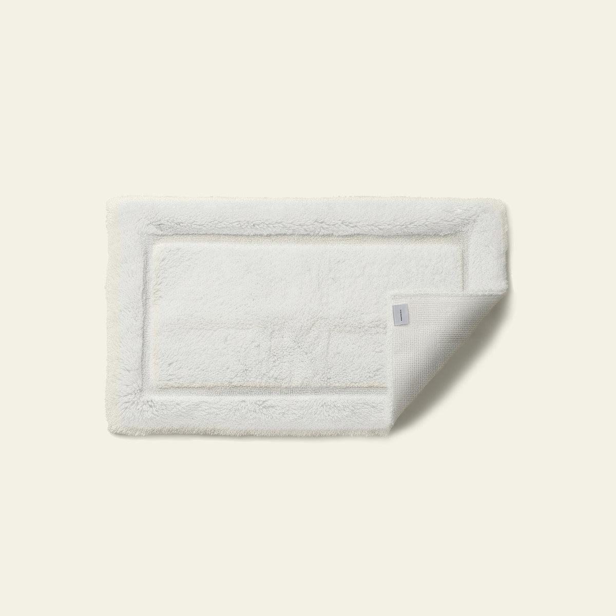 White bath mat on a light beige background