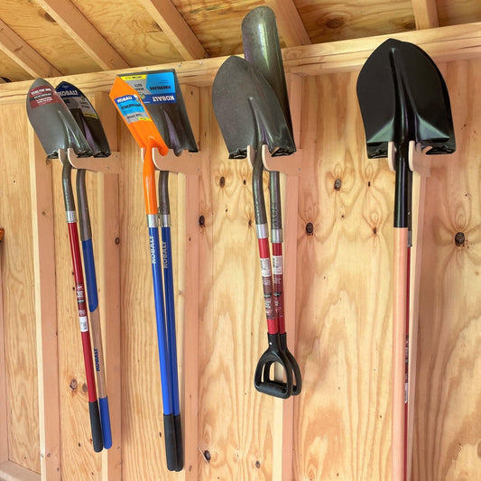 Set of shovels mounted on a wooden wall