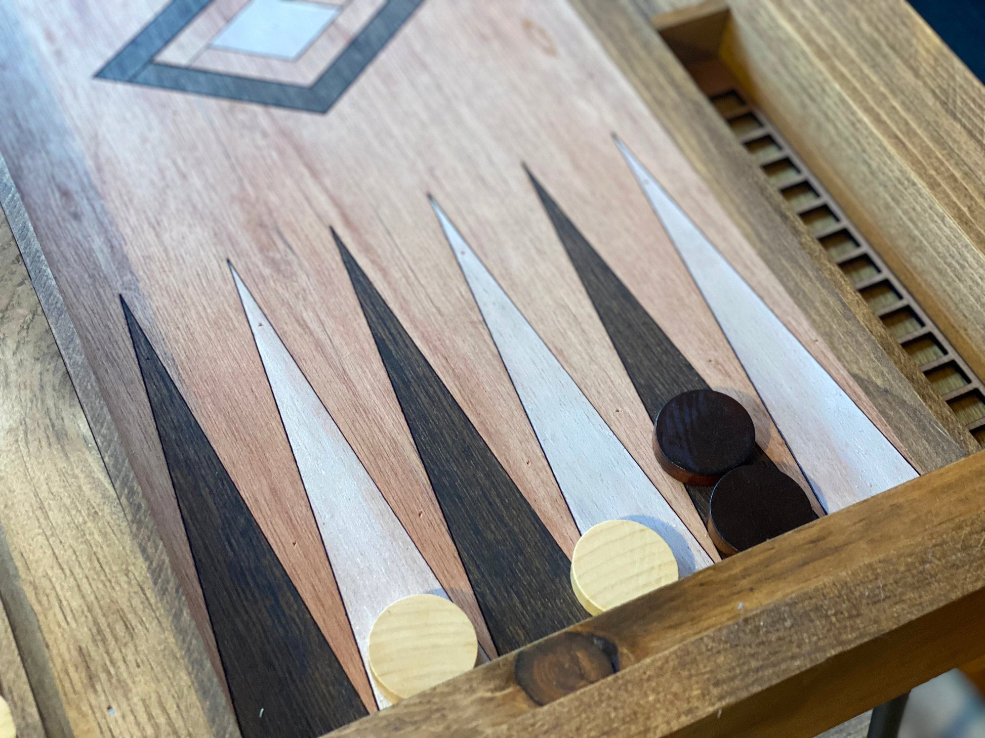Close-up of a wooden backgammon board with pieces.