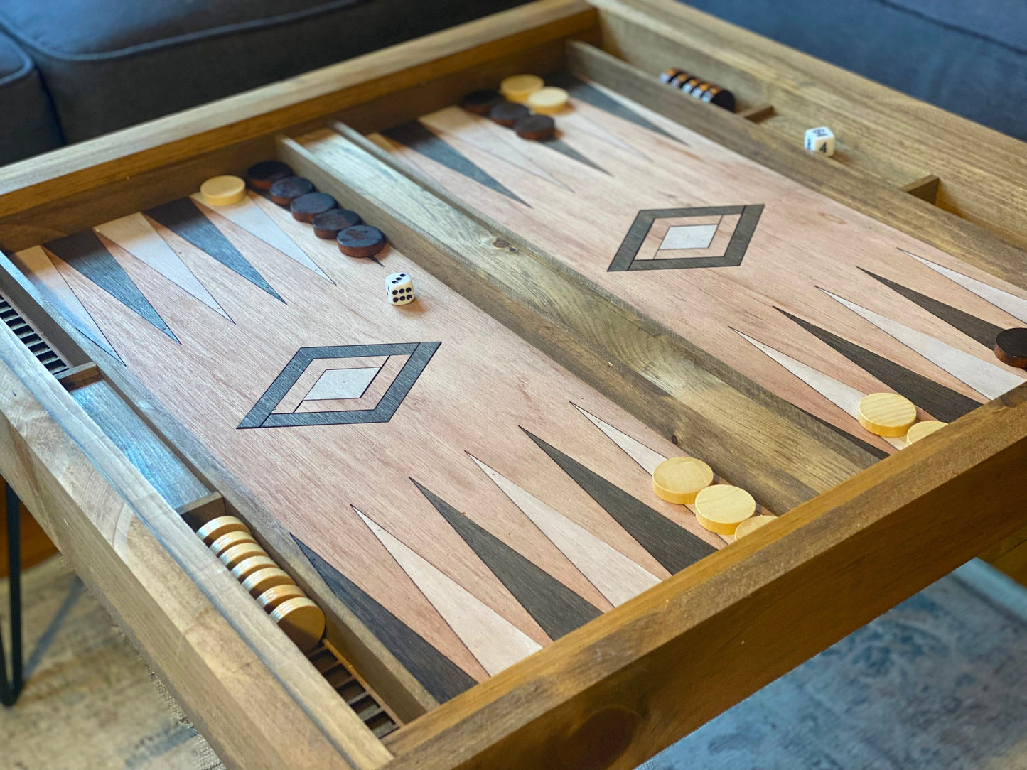 Wooden backgammon board with pieces and dice on a carpeted floor.
