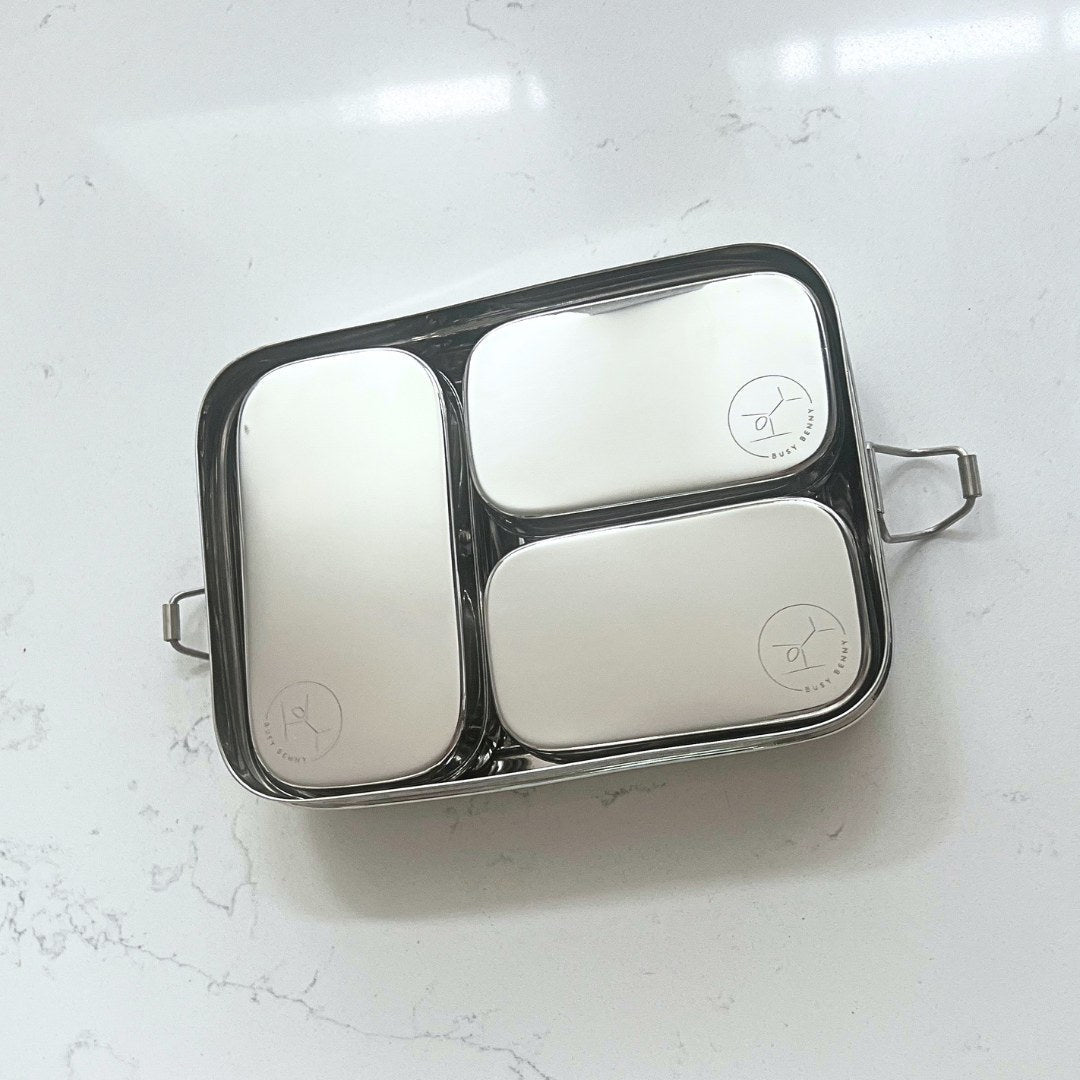 Stainless steel lunch box with compartments on a white surface