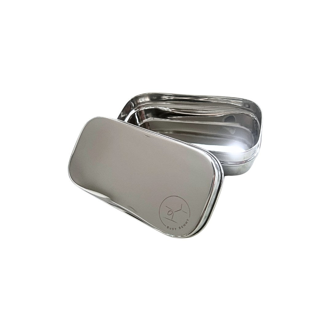 A stainless steel lunch box with a matching lid, shown open on a plain white background. The lid has a subtle circular logo printed on it.
