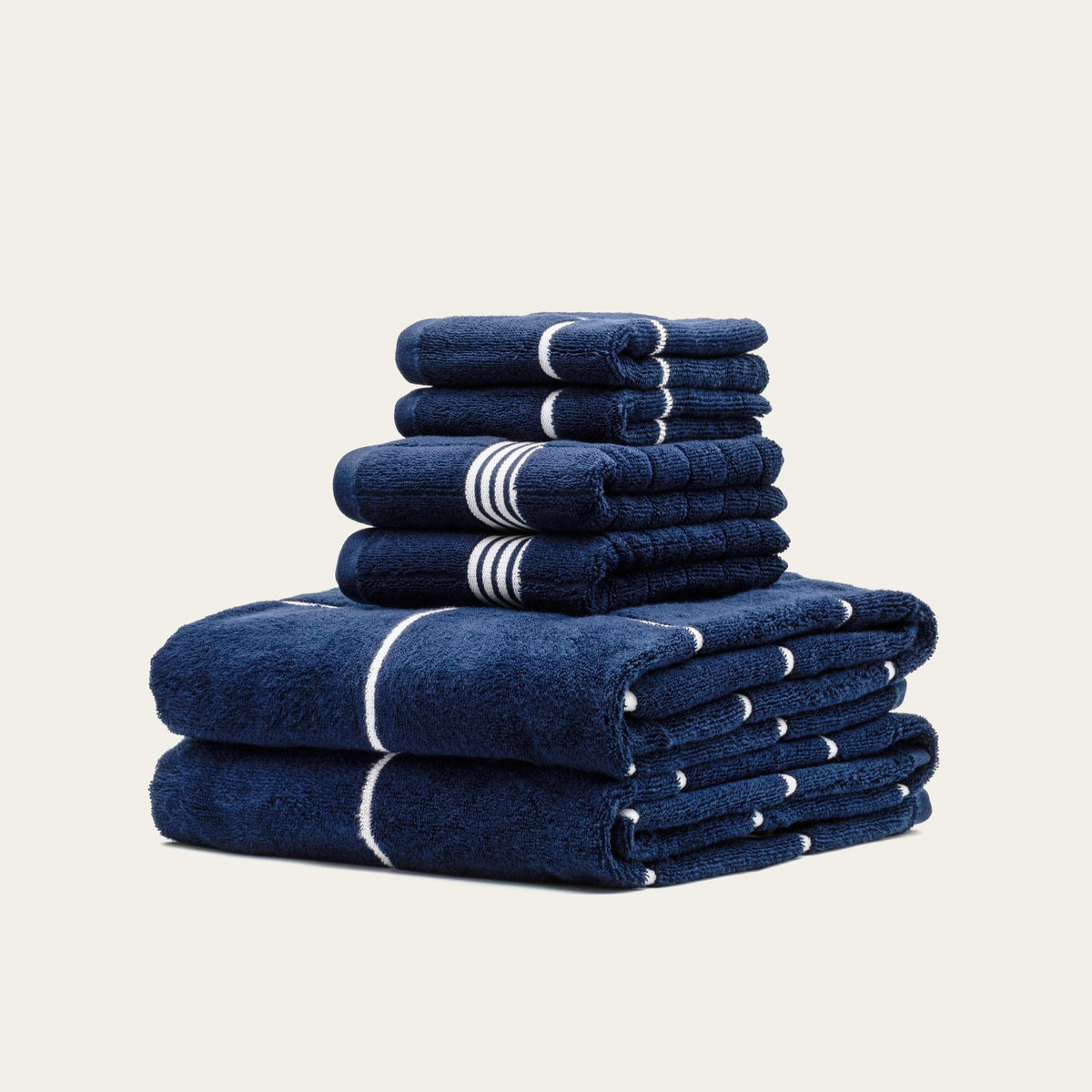 Stack of blue towels with white stripes on a beige background