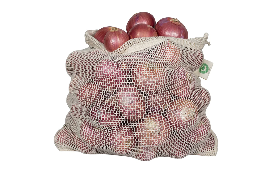 Mesh bag filled with red onions on a white background