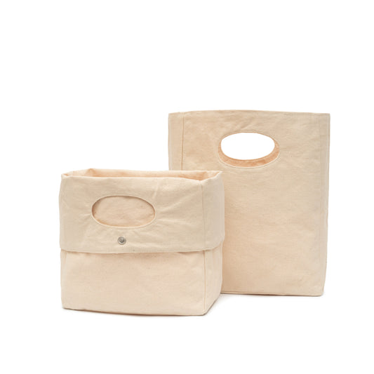 Two beige fabric bags with handles on a white background